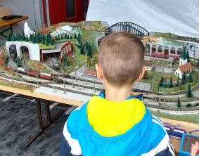 Kleiner Junge schaut auf Eisenbahnlandschaft